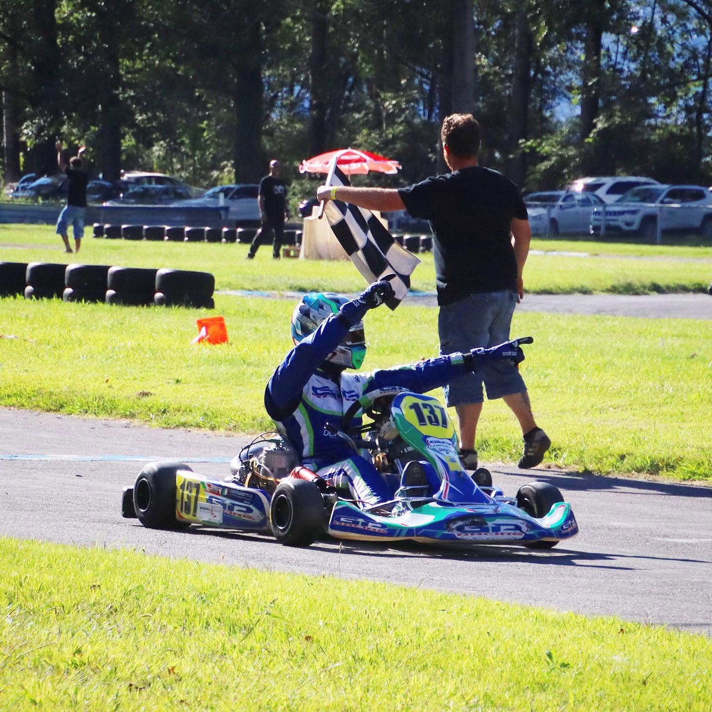 Paolo Castagnetti karting svizzero, pilota in pista con la bandiera a scacchi